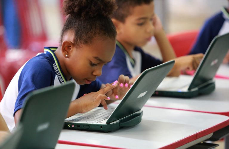 Aluna mexe no computador na escola