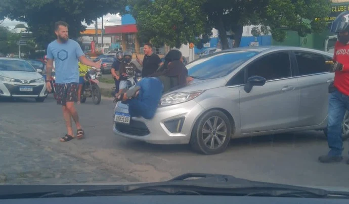 Mulher flagrada em cima do capô de um carro